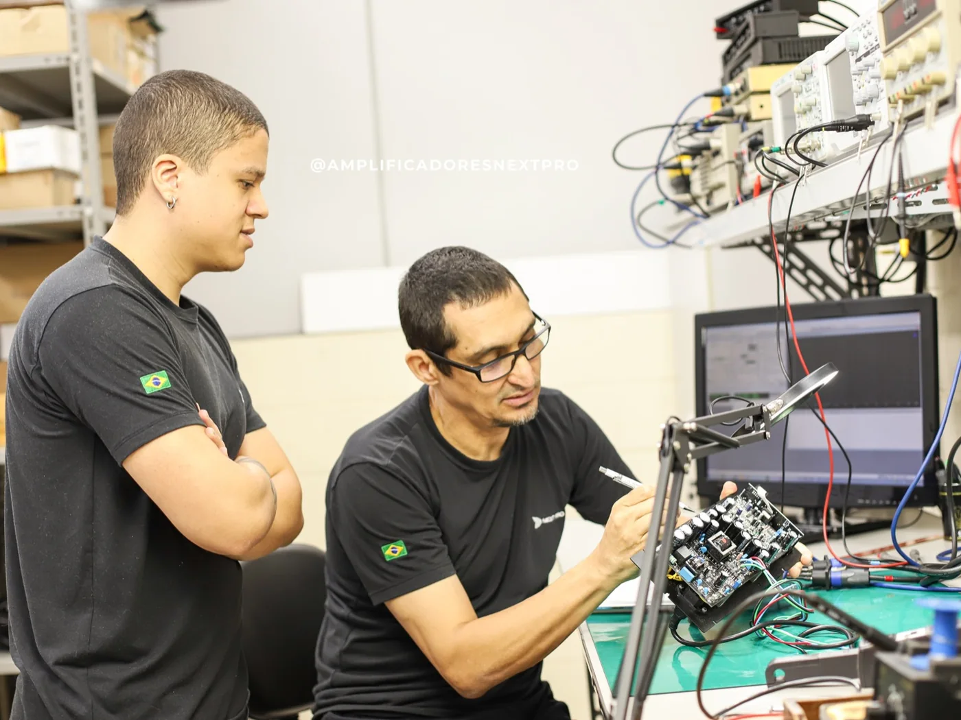 Marcelo Barros e Rafael analisando uma placa na bancada de desenvolvimento da Next Pro