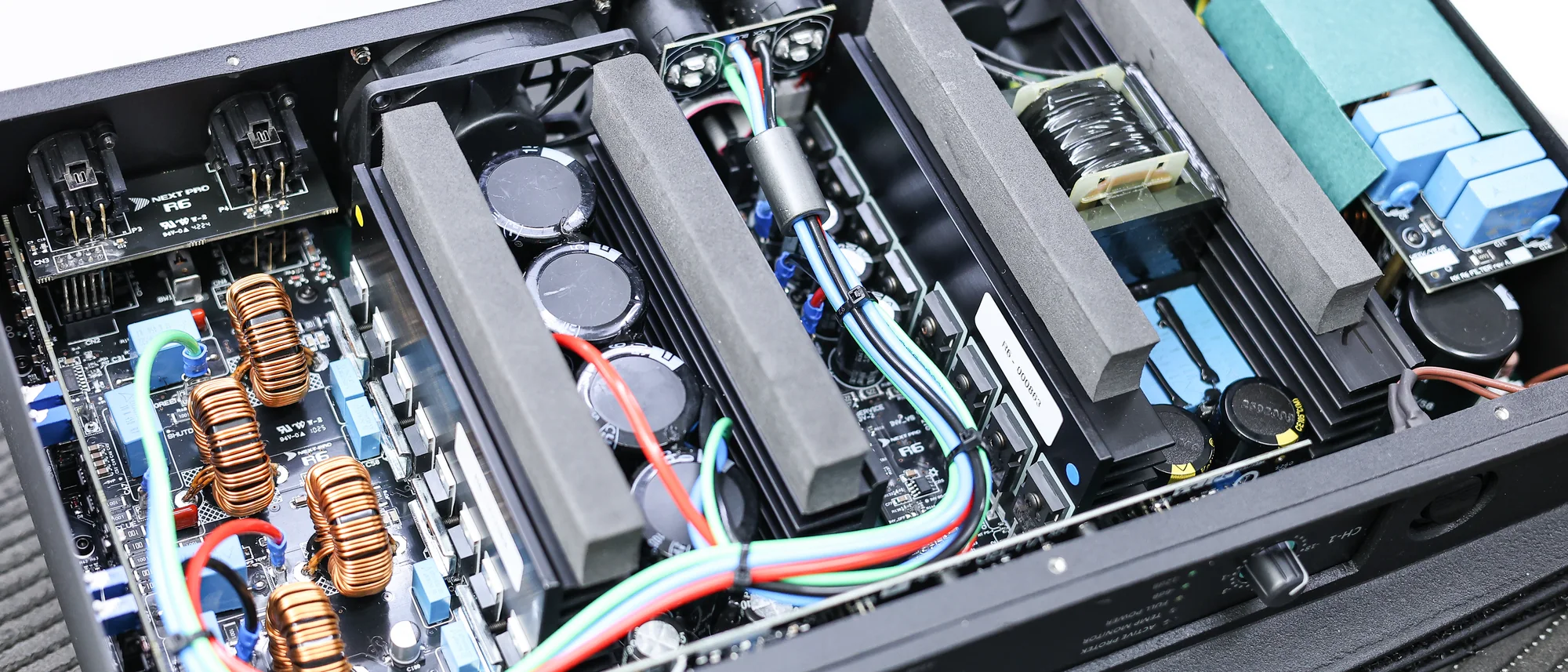 Interior de um amplificador Next Pro aberto, mostrando fonte chaveada, dissipadores e placas montadas
